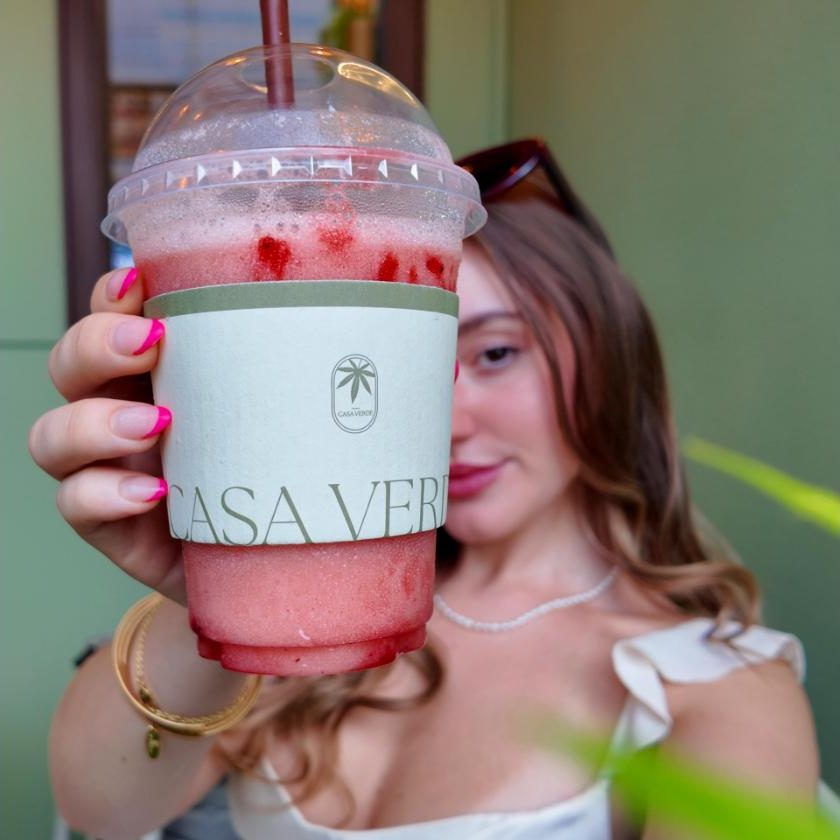 A blended strawberry drink in a Casa Verde branded cup
